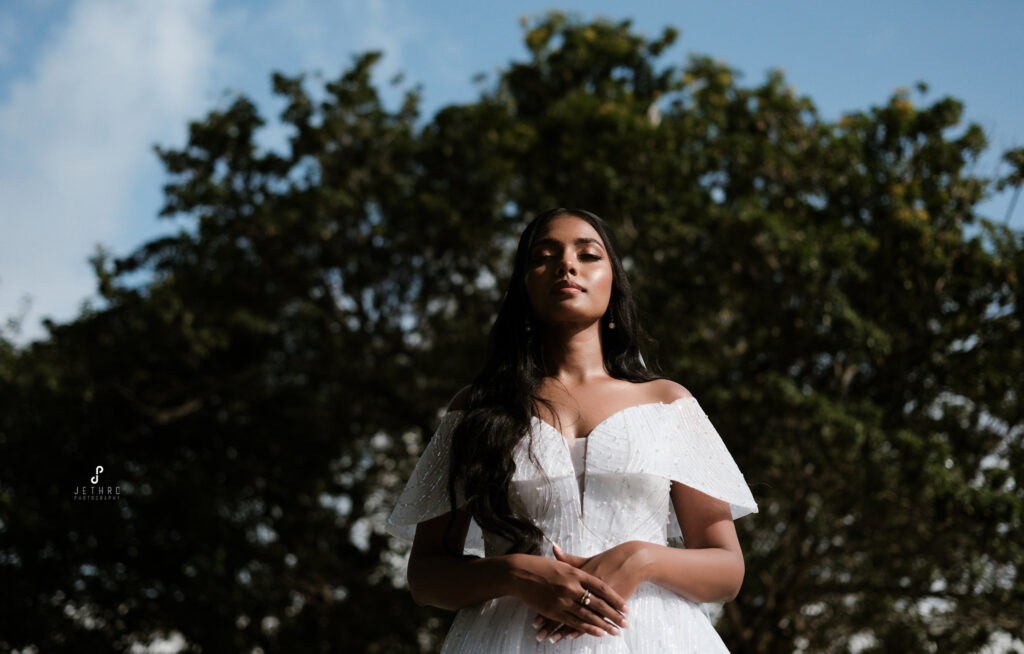 Bride standing in lush garden with soft light and airy color tones